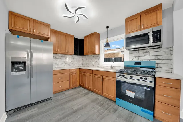 a kitchen with stainless steel appliances granite countertop a stove a refrigerator and a microwave