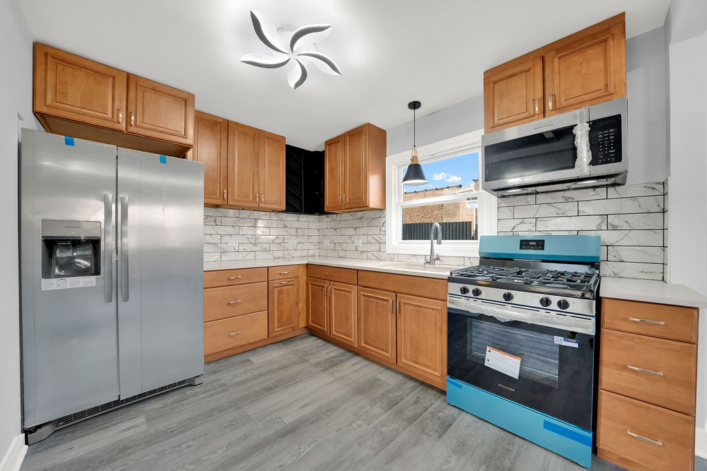 1275 West 71st Street Chicago, IL 60636 - Photo 9 of 21 a kitchen with stainless steel appliances granite countertop a stove a refrigerator and a microwave