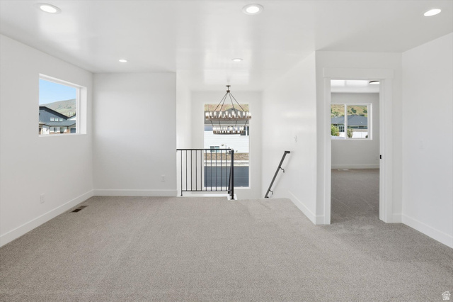 1315 West 3200 South, Unit 17 Perry, UT 84302 - Photo 23 of 58 Spacious loft area featuring light gray carpeting, recessed ceiling lighting, a modern chandelier, white walls, and black metal railing