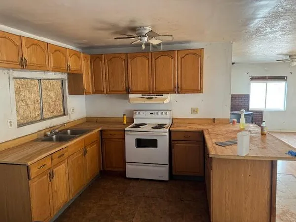 a kitchen with a stove sink and cabinets