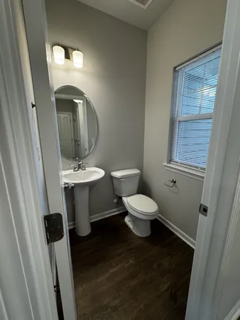 an empty room with wooden floor ceiling fan and windows