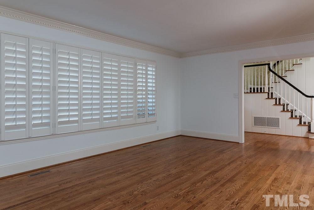 308 Buncombe Street Raleigh, NC 27609 - Photo 3 of 25 a view of an empty room with wooden floor and a window