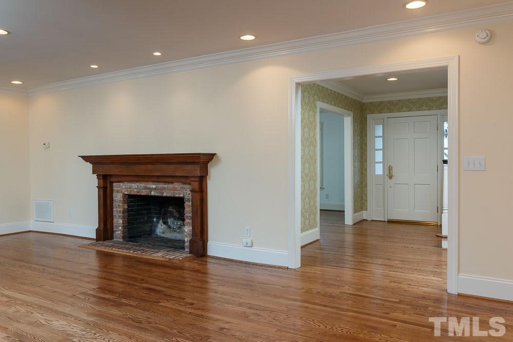308 Buncombe Street Raleigh, NC 27609 - Photo 4 of 25 a view of an empty room with wooden floor and a fireplace