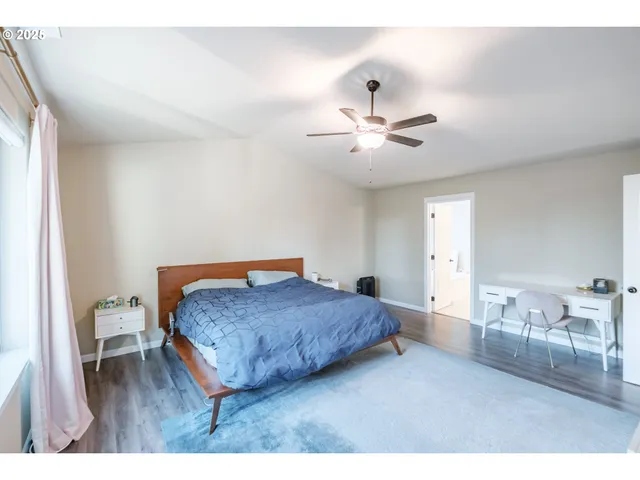 a bedroom with a bed and dresser with mirror