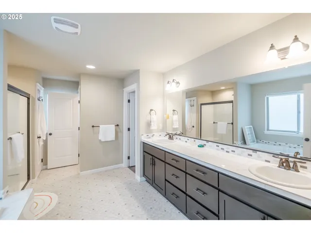 a spacious bathroom with a double vanity sink and a mirror