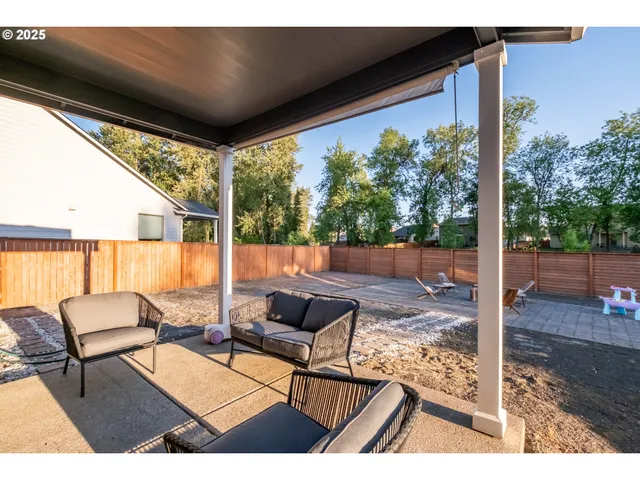 a backyard of a house with table and chairs