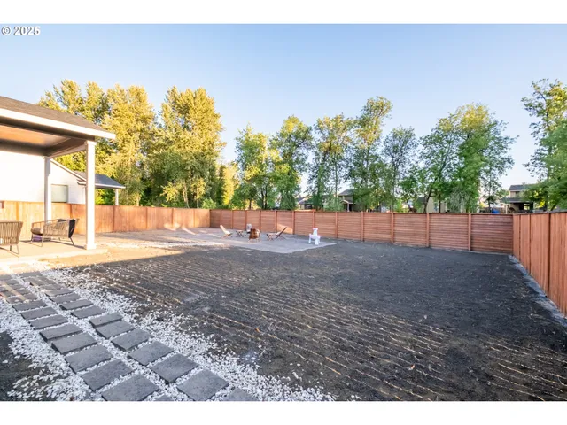 a backyard of a house with table and chairs