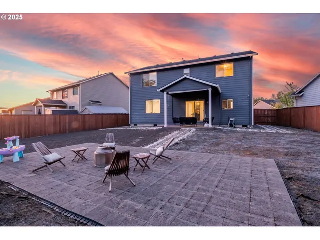 a view of a house with backyard and sitting area