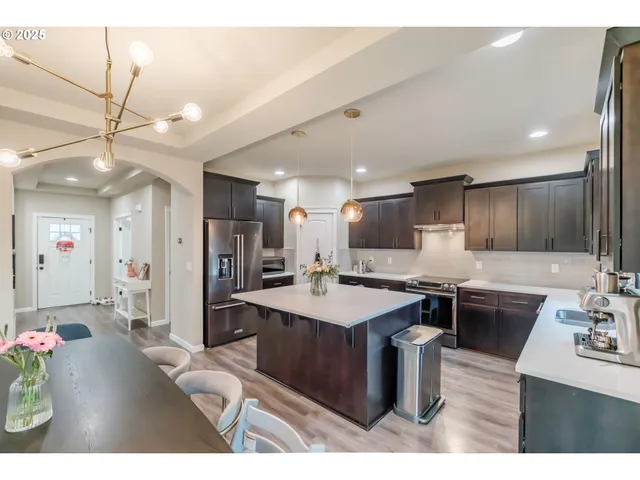 a kitchen with kitchen island granite countertop a sink stainless steel appliances and cabinets