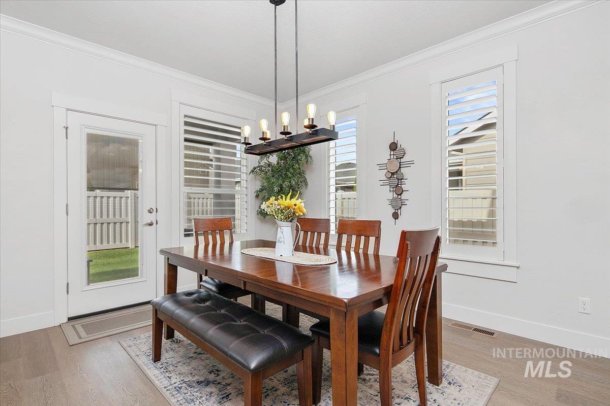 1685 Shoal Point Avenue Middleton, ID 83644 - Photo 20 of 44 Dining space featuring crown molding, light wood-style floors, and a chandelier