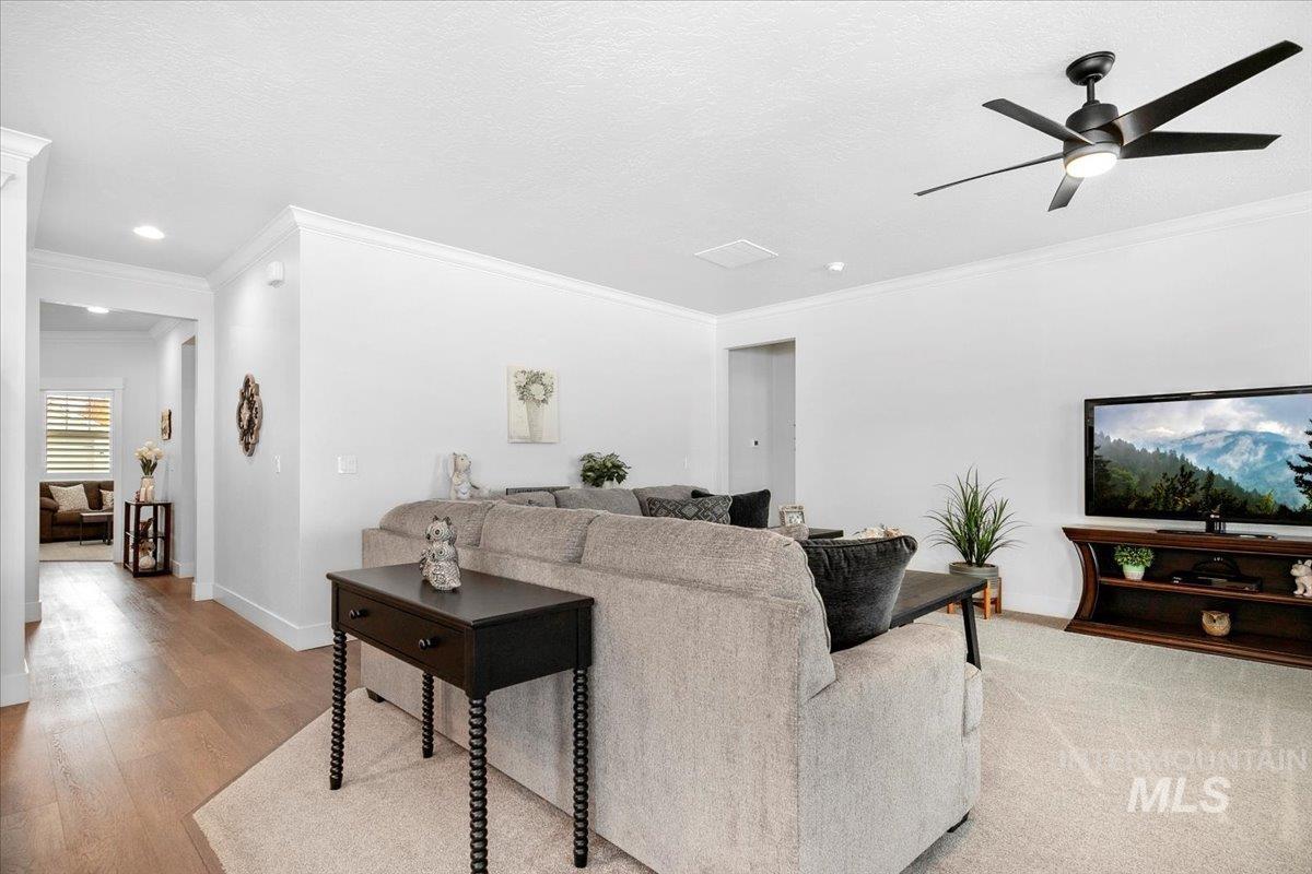 1685 Shoal Point Avenue Middleton, ID 83644 - Photo 22 of 44 Living room featuring crown molding, a ceiling fan, a textured ceiling, and light wood-style flooring