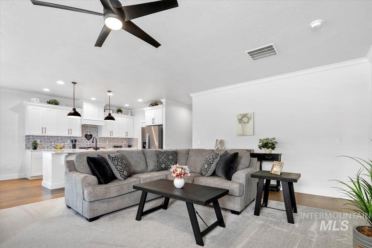1685 Shoal Point Avenue Middleton, ID 83644 - Photo 24 of 44 Living room featuring crown molding, light wood-type flooring, a textured ceiling, ceiling fan, and recessed lighting