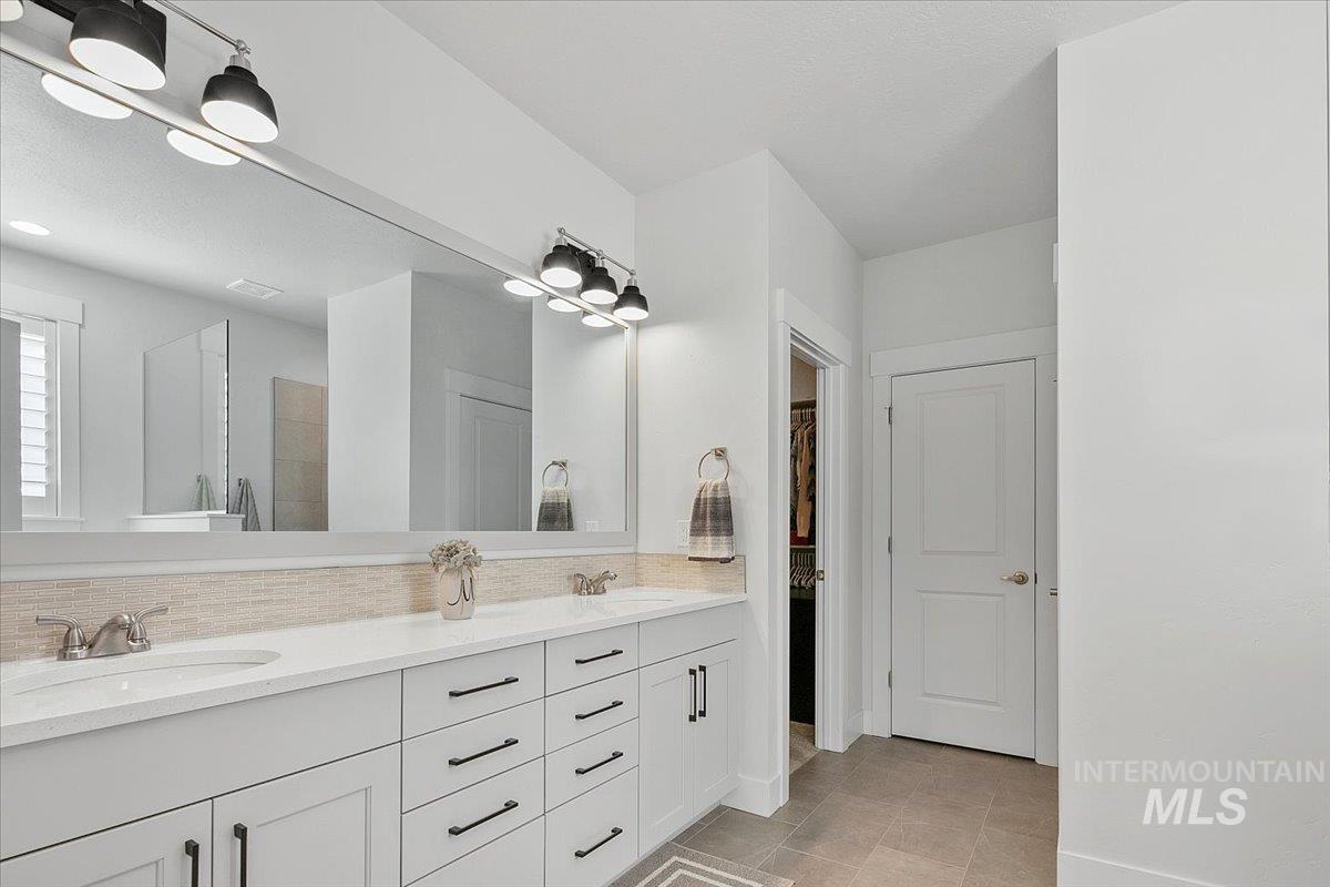 1685 Shoal Point Avenue Middleton, ID 83644 - Photo 28 of 44 Full bath featuring double vanity, a walk in shower, backsplash, a spacious closet, and light tile patterned floors