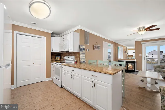a kitchen with granite countertop a sink cabinets and wooden floor