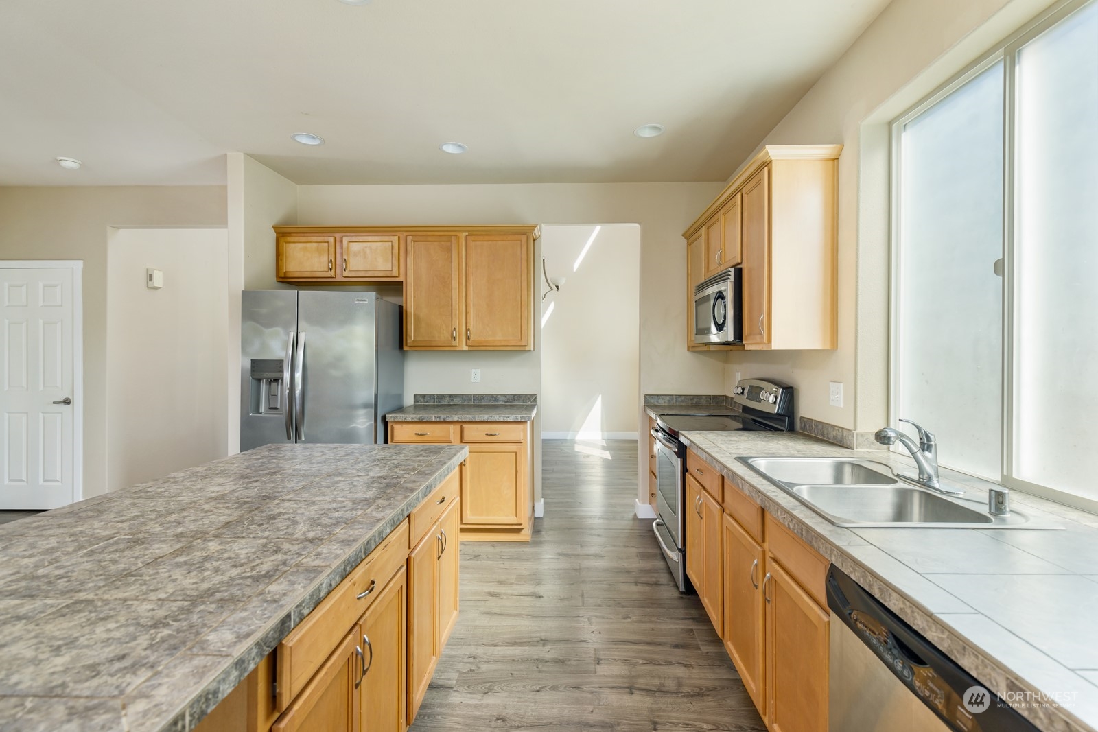 7365 Radius Loop Southeast Lacey, WA 98513 - Photo 16 of 24 a large kitchen with stainless steel appliances granite countertop a sink and a refrigerator