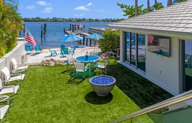 a view of a patio with a table and chairs under an umbrella
