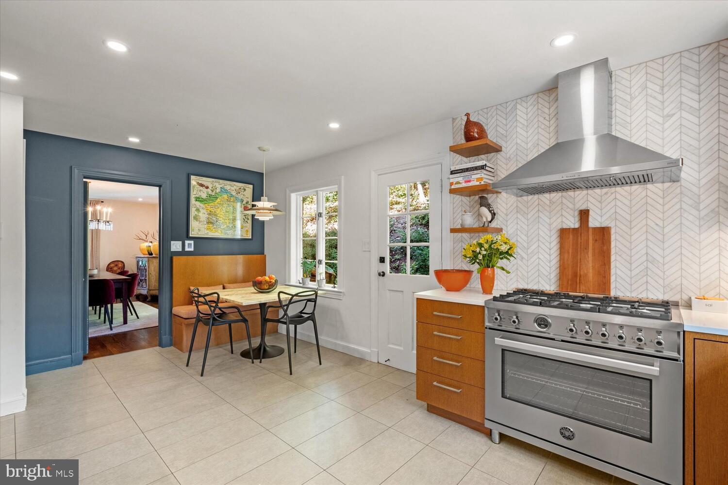 4838 Broad Branch Road Northwest Washington, DC 20008 - Photo 13 of 33 a kitchen with stainless steel appliances a stove a chimney a dining table and chairs