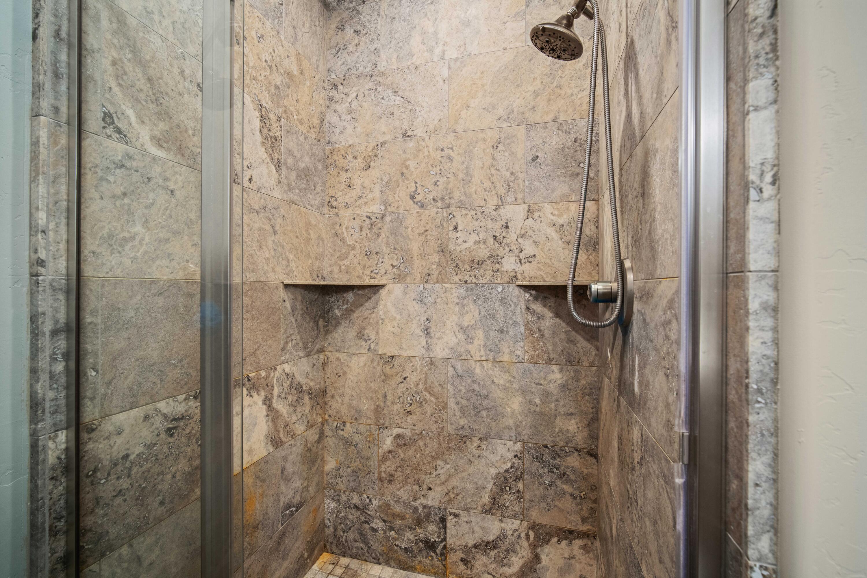 16927 Covina Road Bend, OR 97707 - Photo 20 of 54 Walk-in tile shower in this Bend, Oregon primary bath, finished with earthy tones that complement the home?s warm and elevated character.