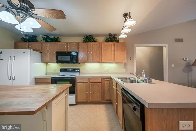 a kitchen with a sink a stove and chairs
