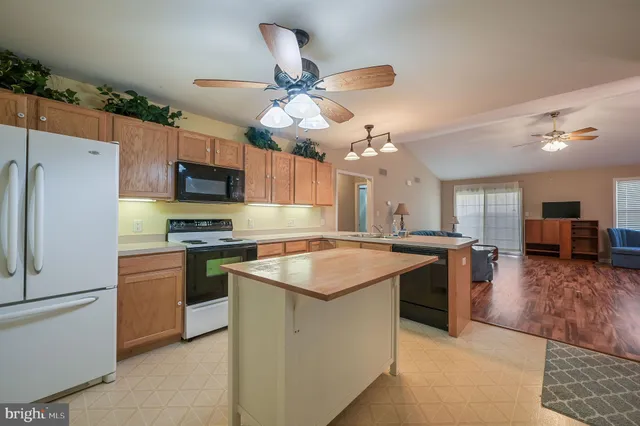 a kitchen with kitchen island a sink stainless steel appliances and cabinets