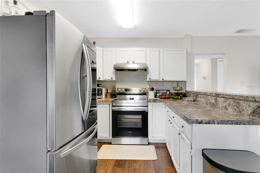 498 Clemson Drive Altamonte Springs, FL 32714 - Photo 9 of 31 a kitchen with a stove top oven and cabinets