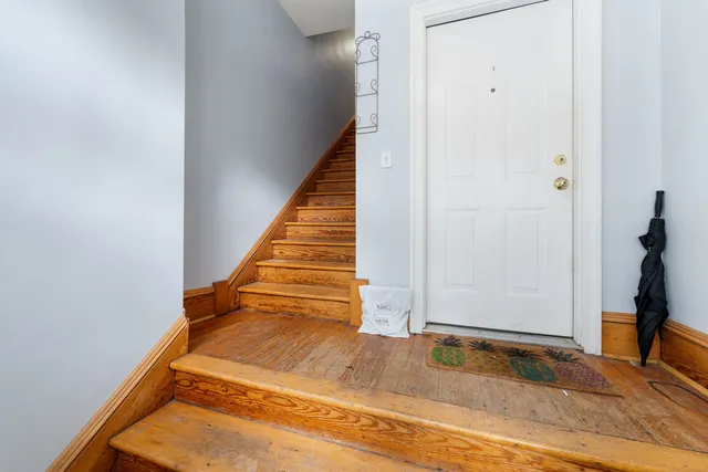 a view of a hallway with wooden floor and staircase