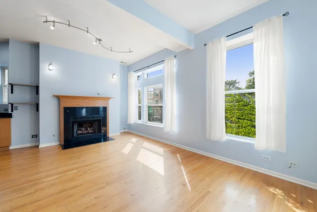 a view of an empty room with a window and fireplace