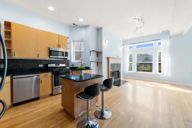 a kitchen with granite countertop a sink cabinets and wooden floor