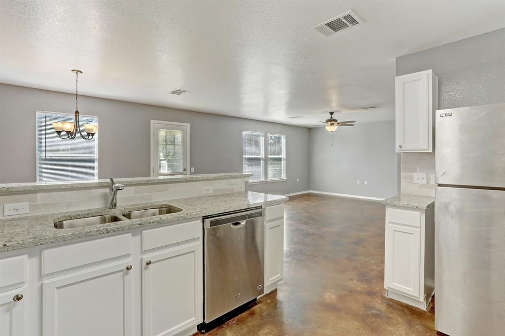 5913 Silver Screen Drive Austin, TX 78747 - Photo 5 of 31 a kitchen with a sink and a refrigerator