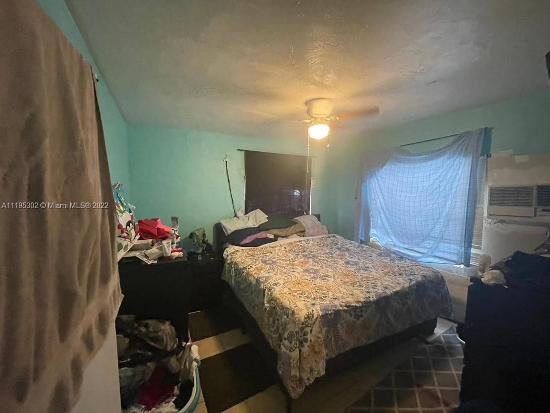3040 Northwest 13th Avenue Miami, FL 33142 - Photo 13 of 51 a bedroom with a bed and a chandelier
