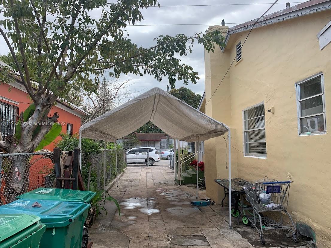 3040 Northwest 13th Avenue Miami, FL 33142 - Photo 30 of 51 a view of a patio with table and chairs under an umbrella