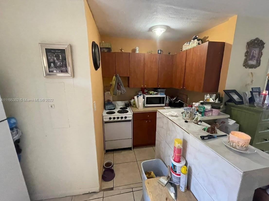 3040 Northwest 13th Avenue Miami, FL 33142 - Photo 37 of 51 a kitchen with stainless steel appliances a stove a refrigerator and a dining table