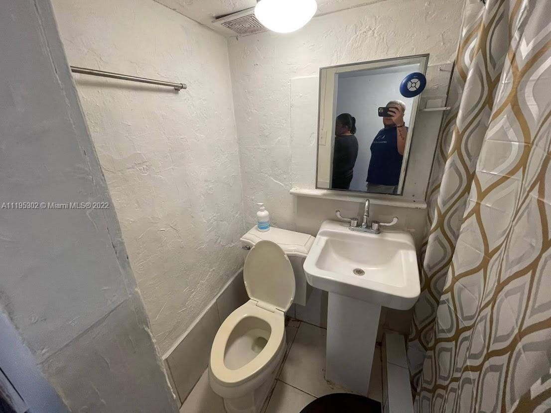 3040 Northwest 13th Avenue Miami, FL 33142 - Photo 50 of 51 a bathroom with a toilet sink and mirror