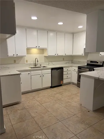 a kitchen with stainless steel appliances granite countertop a sink counter space cabinets and a stove