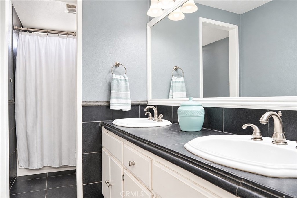 2164 North Date Avenue Rialto, CA 92377 - Photo 11 of 20 Hall bathroom with dual sinks, updtaed cabinetry and tiled shower area.