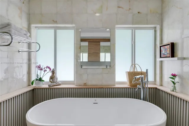 a view of a patio with table and chairs potted plants and floor to ceiling window