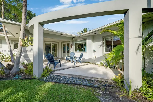 a view of a house with pool and chairs