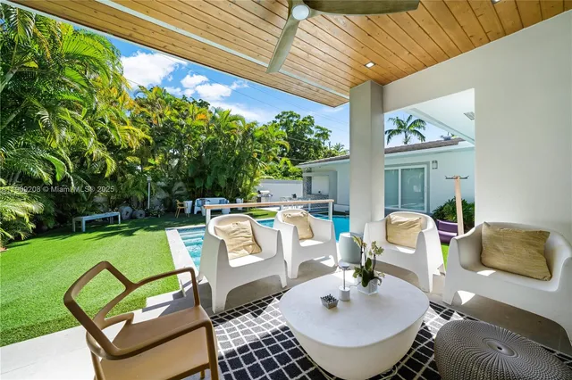 a view of backyard with swimming pool and outdoor seating