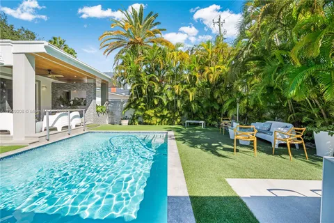 a view of a swimming pool with a yard and sitting area