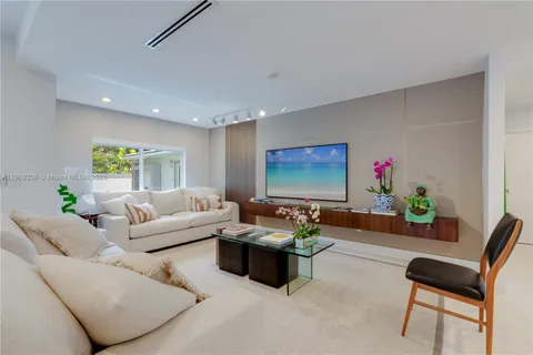a living room with furniture flower pot and a large window