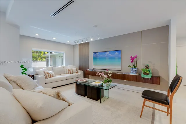 a living room with furniture flower pot and a large window