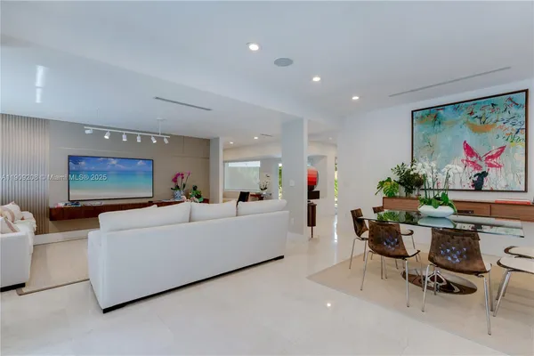 a living room with furniture a dining table and a potted plant