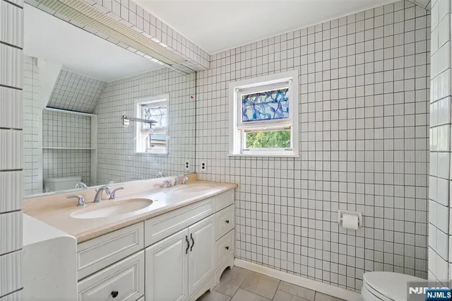 a bathroom with a sink a toilet and mirror