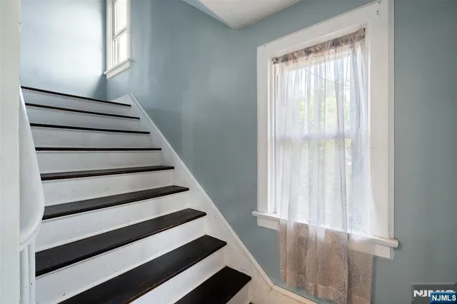 a front view of a house with a yard and potted plants