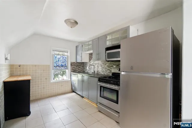 a kitchen with stainless steel appliances granite countertop a refrigerator and a stove top oven