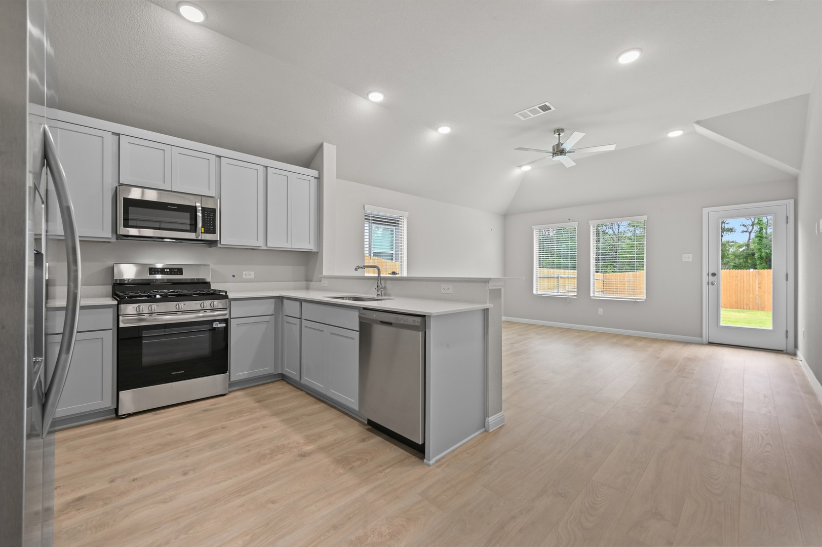 332 Bendecido Loop Elgin, TX 78621 - Photo 16 of 39 a kitchen with granite countertop a refrigerator stove top oven and sink