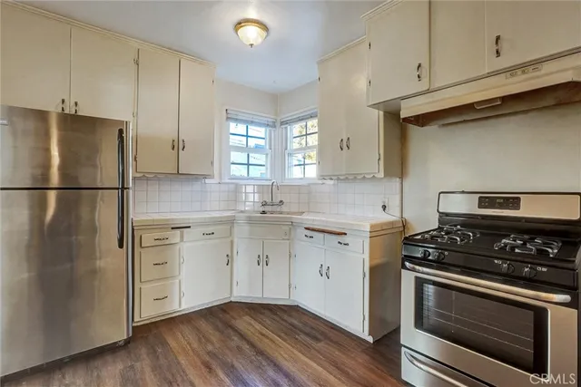a kitchen with appliances a sink cabinets and wooden floor