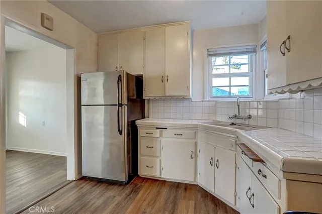 a kitchen with a refrigerator sink and cabinets
