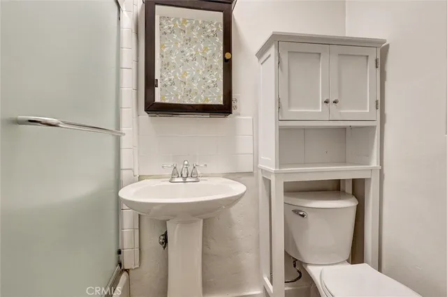 a bathroom with a toilet sink and mirror