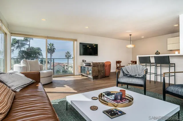 a living room with furniture a flat screen tv and a table